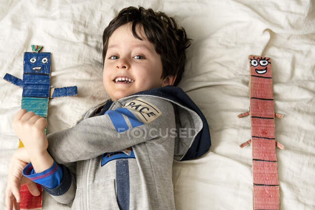 UK, Portrait of smiling boy lying on bed — Stock Photo