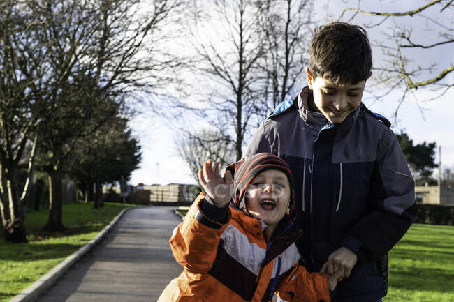 Великобритания, Два улыбающихся мальчика (4-5, 10-11) на улице — стоковое фото