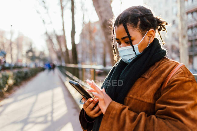 Italien, Frau mit Gesichtsmaske textet im Freien — Stockfoto