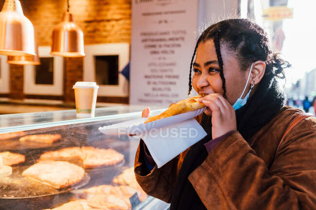 Itália, Mulher comer lanche no stand de comida de rua — Fotografia de Stock