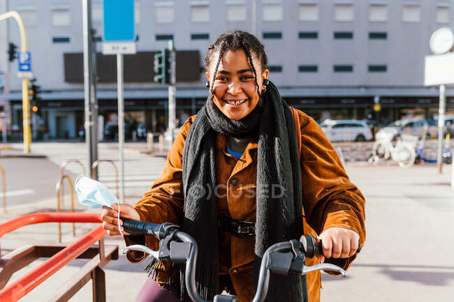Italy, Portrait of smiling young woman with bicycle on city street — Stock Photo