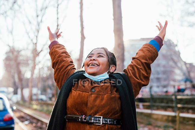 Italien, junge lächelnde Frau mit erhobenen Armen im Freien — Stockfoto