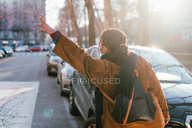 Італія, вид жінки, що вітає таксі на вулиці. — стокове фото