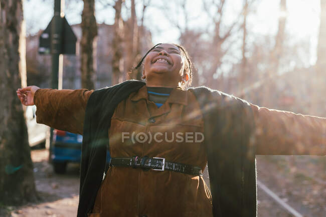 Italy, Young smiling woman with arms outstretched outdoors — Stock Photo