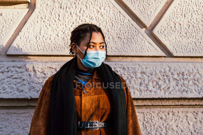 Италия, молодая женщина в маске, стоящая у стены — стоковое фото