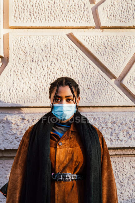 Itália, Retrato de jovem mulher na máscara de pé na parede — Fotografia de Stock
