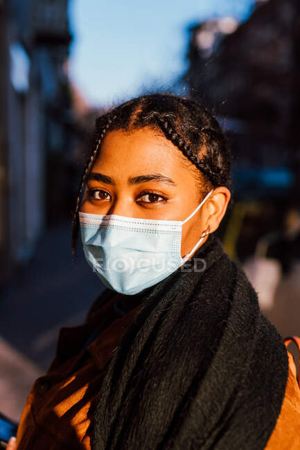 Италия, портрет молодой женщины в маске, стоящей на городской улице — стоковое фото