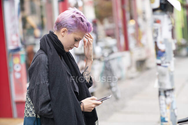 Jovem mulher usando telefone na rua da cidade — Fotografia de Stock