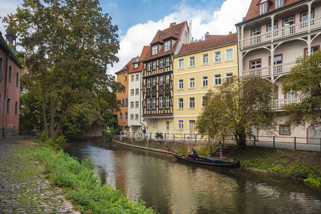 Germany, Bavaria, Bamberg, Gondola docked on river along townhouses — Stock Photo
