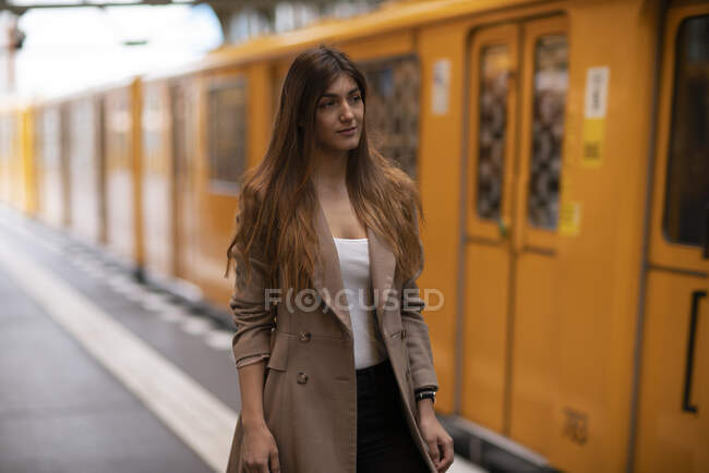 Німеччина, Берлін, молода жінка стоїть на залізничному вокзалі. — стокове фото