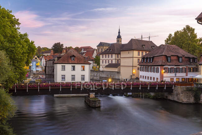 Germany, Bavaria, Bamberg, Townscape with bridge over river at dusk — Stock Photo
