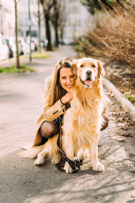 Italy, Portrait of young woman with dog on sidewalk — Stock Photo