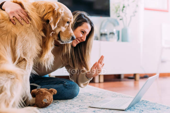 Italia, Mujer joven con perro mirando el ordenador portátil - foto de stock