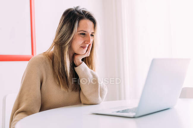 Italia, Mujer joven usando el ordenador portátil en casa - foto de stock