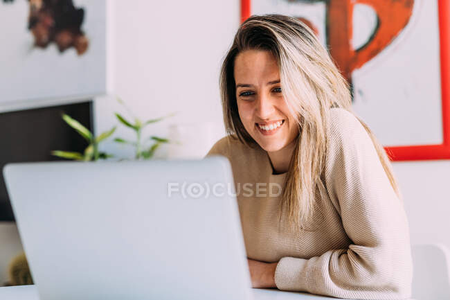 Italy, Young woman using laptop at home — Stock Photo