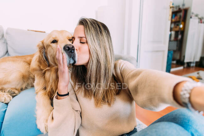 Italien, Junge Frau küsst Hund zu Hause — Stockfoto