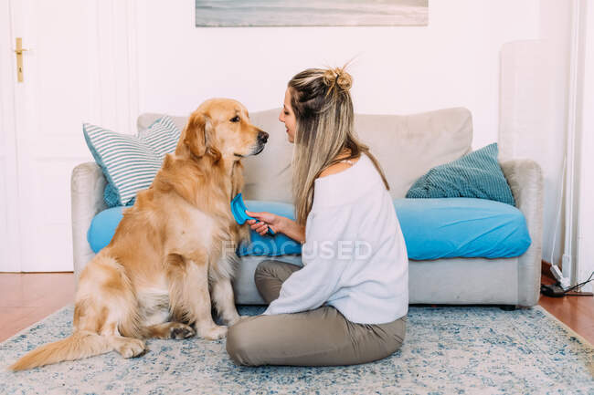 Italy, Young woman and dog at home — Stock Photo