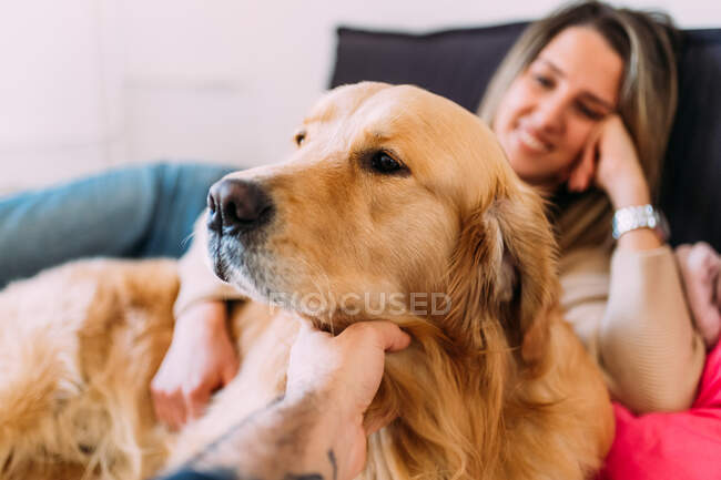 Italy, Young woman and dog relaxing on bed — Stock Photo