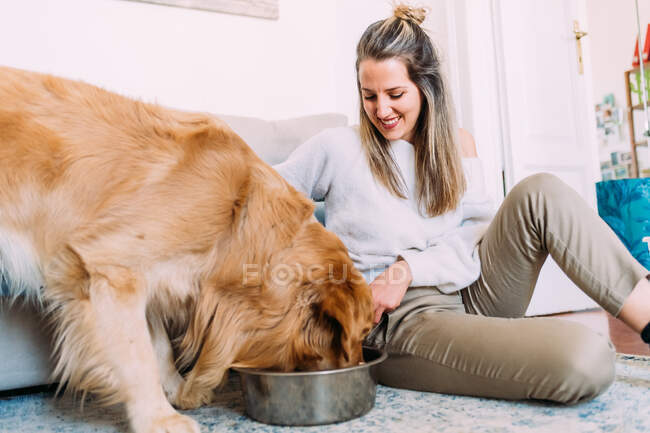Italy, Young woman feeding dog — Stock Photo