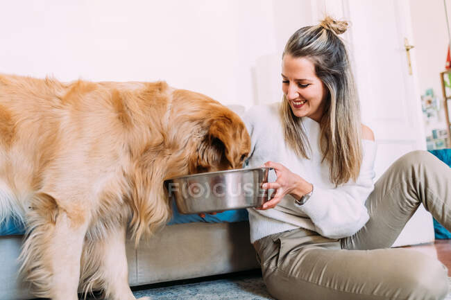 Italy, Woman holding bowl for dog to eat — Stock Photo