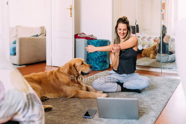 Italy, Young woman with dog relaxing at home — Stock Photo