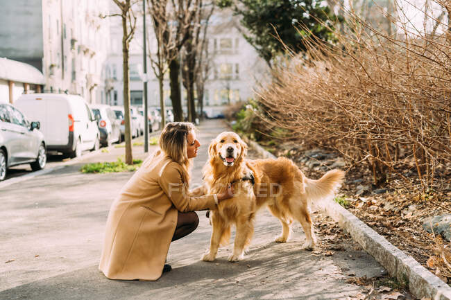 Italia, Giovane donna con cane sul marciapiede — Foto stock