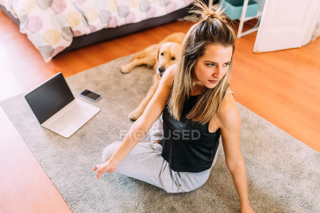 Italy, Young woman using laptop on floor — Stock Photo