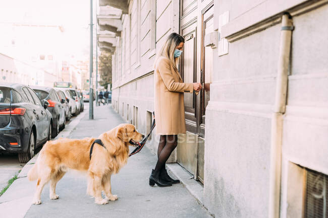 Италия, женщина с собакой входит в квартиру — стоковое фото