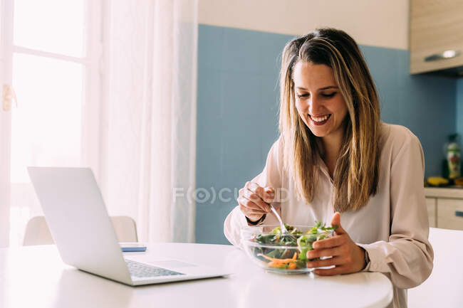 Itália, Mulher comendo salada na cozinha — Fotografia de Stock