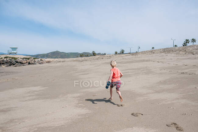 EUA, Califórnia, Ventura, Vista traseira do menino correndo na praia — Fotografia de Stock