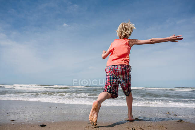 USA, Kalifornien, Ventura, Rückansicht eines Jungen, der am Strand läuft — Stockfoto