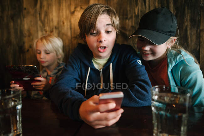 Estados Unidos, California, San Francisco, Los niños mirando los teléfonos inteligentes - foto de stock
