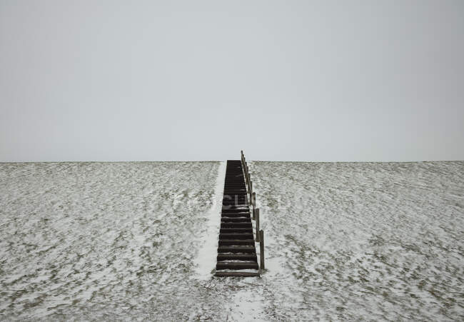 Netherlands, Friesland, Wierum, Steps in snow covered field — Stock Photo