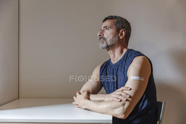 Francia, Uomo con benda sul braccio seduto a tavola — Foto stock