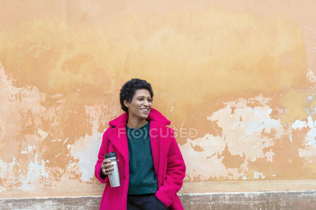 Italia, Toscana, Pistoia, Mujer sonriente sosteniendo envase de bebida aislada - foto de stock