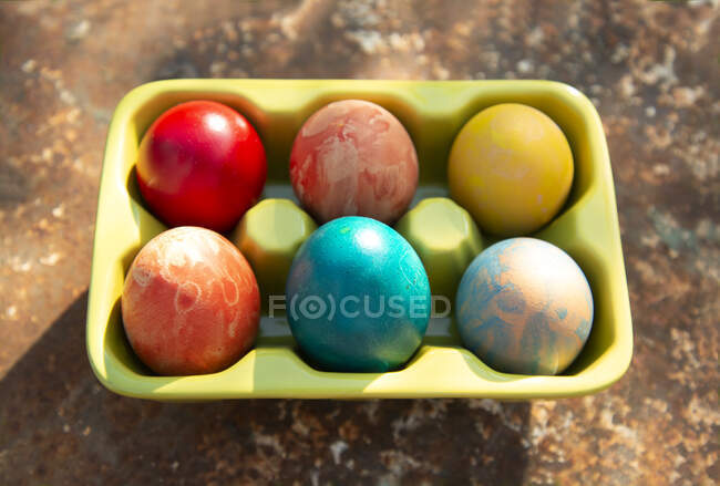 Italie, Turin, œufs colorés mangeur dans le carton d'oeufs — Photo de stock