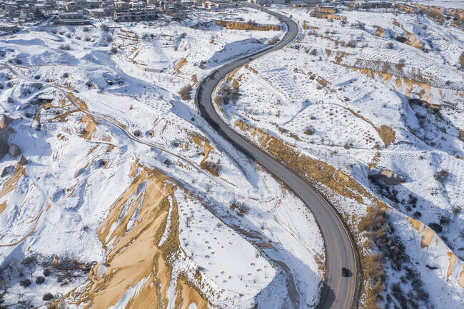 Turquia, Capadócia, Vista aérea da estrada sinuosa em paisagem rochosa no inverno — Fotografia de Stock