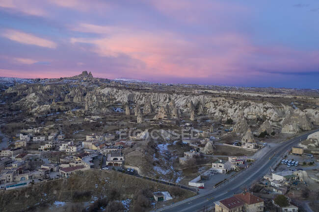 Turkey, Cappadocia, Aerial view of rock formations and village at dusk — Stock Photo