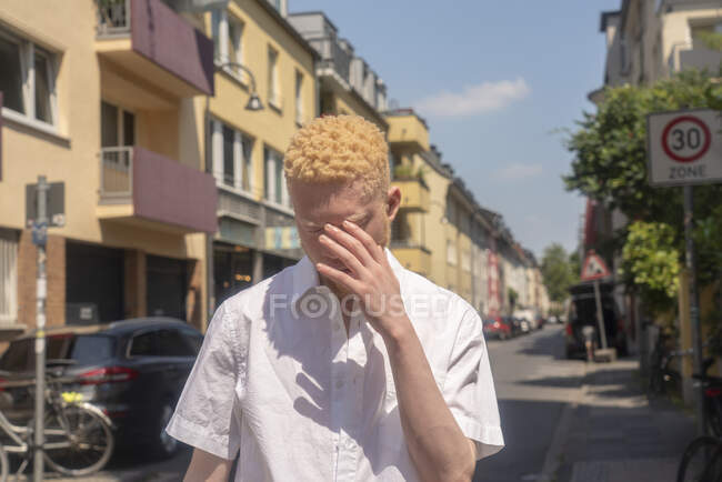 Germany, Cologne, Albino man in white shirt on street — Stock Photo