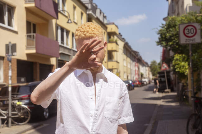 Germany, Cologne, Albino man in white shirt on street — Stock Photo