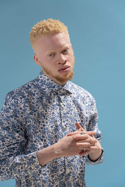 Studio portrait of albino man in blue patterned shirt — Stock Photo