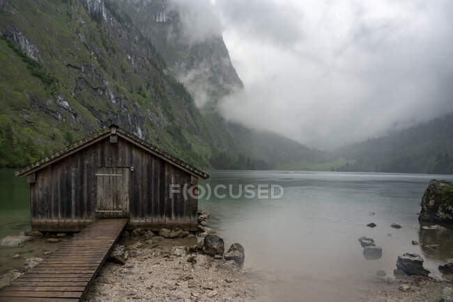 Germany, Bavaria, Pier with old wooden building on Obersee — Stock Photo