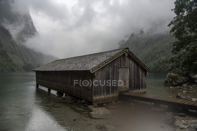 Allemagne, Bavière, Quai avec vieux bâtiment en bois sur Obersee — Photo de stock