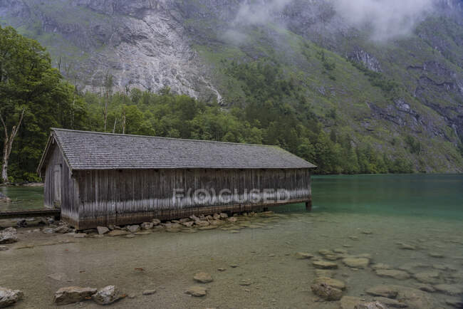 Germany, Bavaria, Pier with old wooden building on Obersee — Stock Photo
