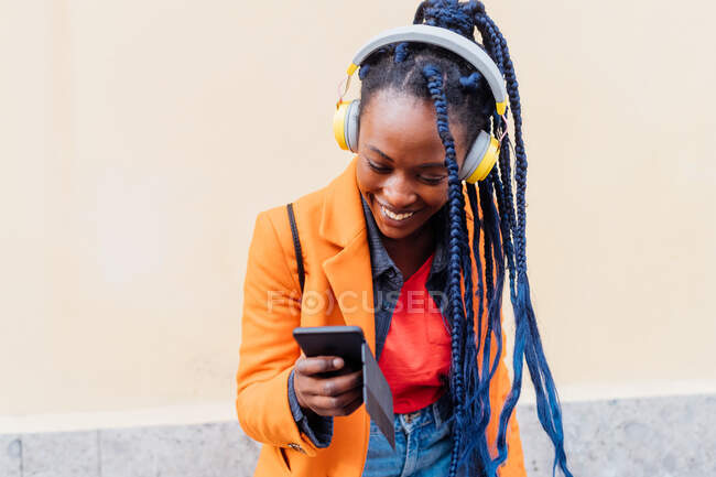 Italy, Milan, Woman with headphones and smart phone outdoors — Stock Photo