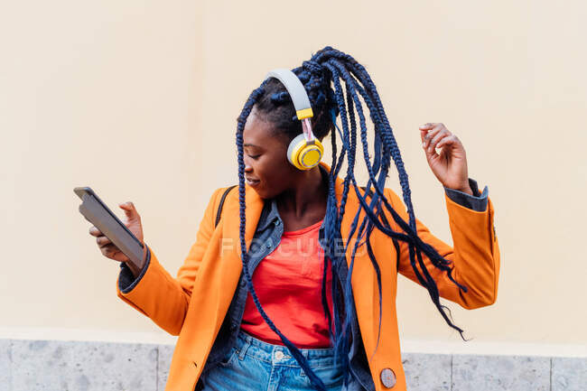 Italy, Milan, Woman with headphones and smart phone dancing outdoors — Stock Photo
