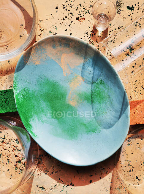 Overhead view of painted stone plate and glasses — Stock Photo