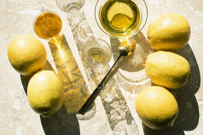 Vue aérienne des citrons et des boissons sur la surface du marbre — Photo de stock