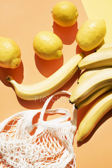 Vista aérea de bananas, limões e saco de malha — Fotografia de Stock