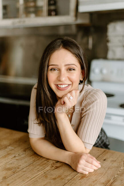 Портрет усміхненої молодої жінки з рукою на підборідді — стокове фото